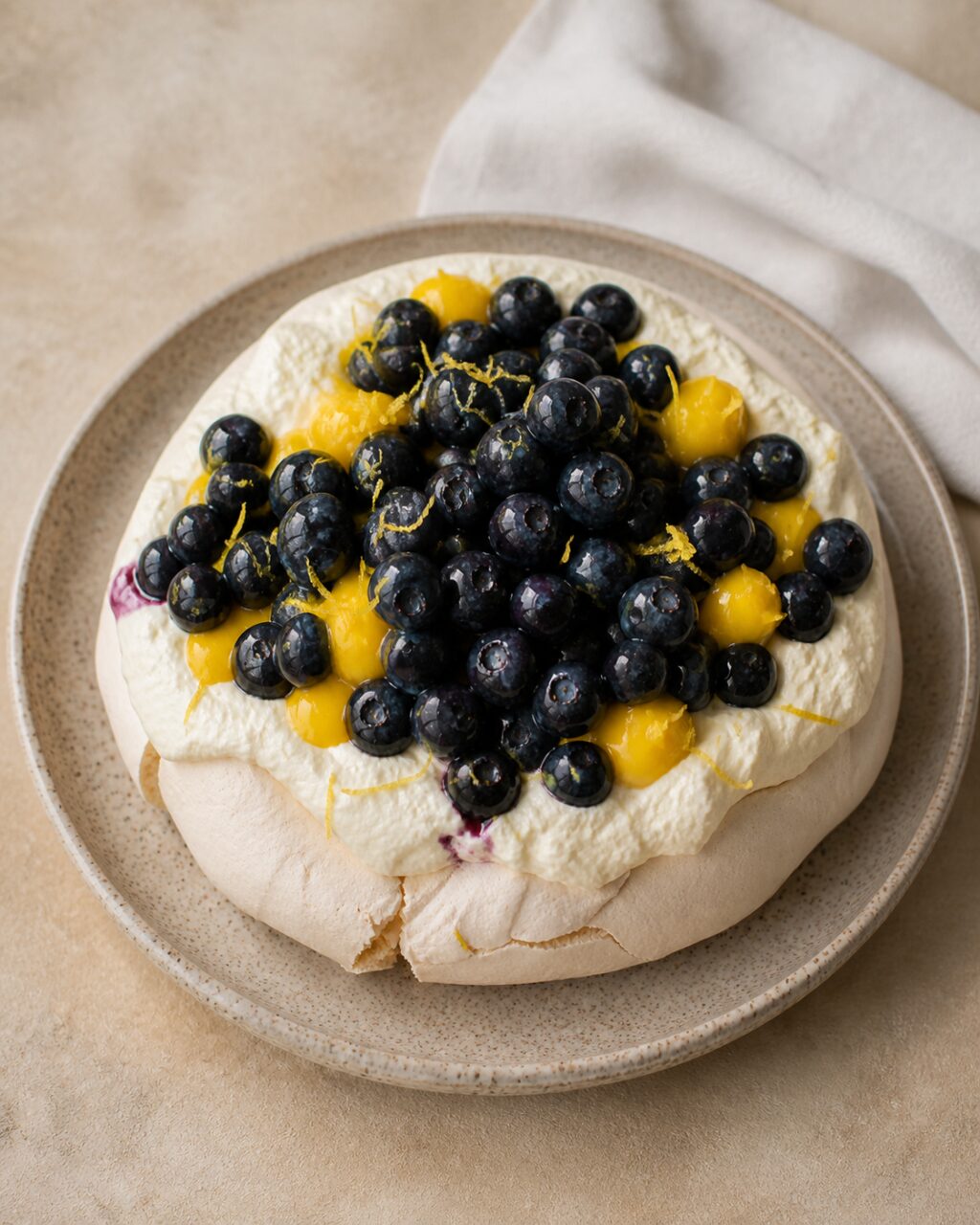 A generous layer of glossy blueberries tops the lemon pavlova