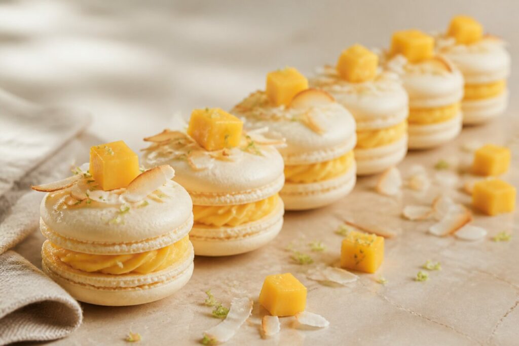 Coques ivoire de six macarons coco-mangue coiffés de fruit