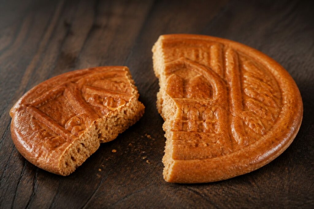 Couque de Dinant brisée révélant une mie dense et sèche, macro de biscuit wallon