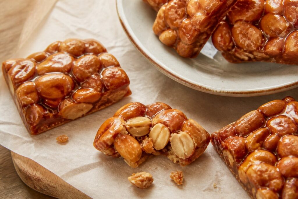 Doce de ginguba angolais aux cacahuètes grillées, carrés de caramel cassés sur bois