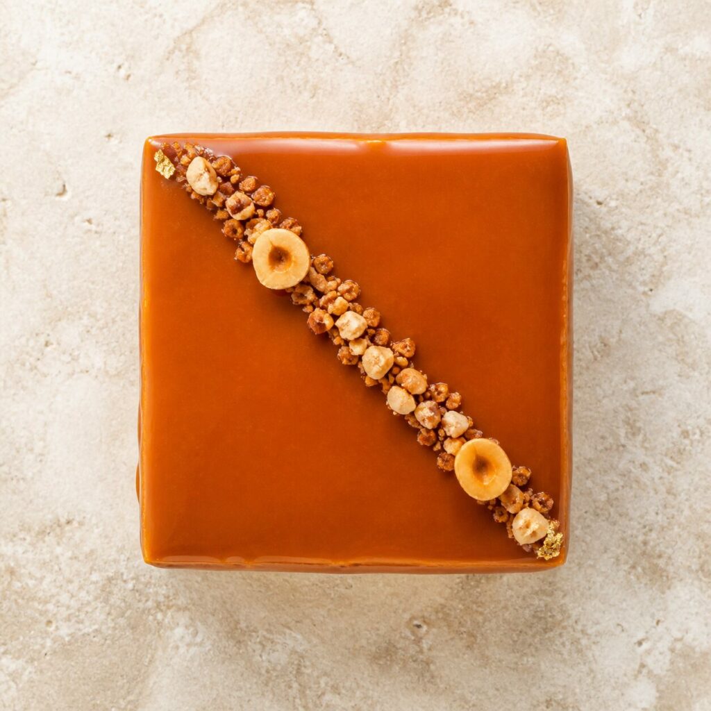 Caramel brillant et ligne de noisettes sur l'entremets
