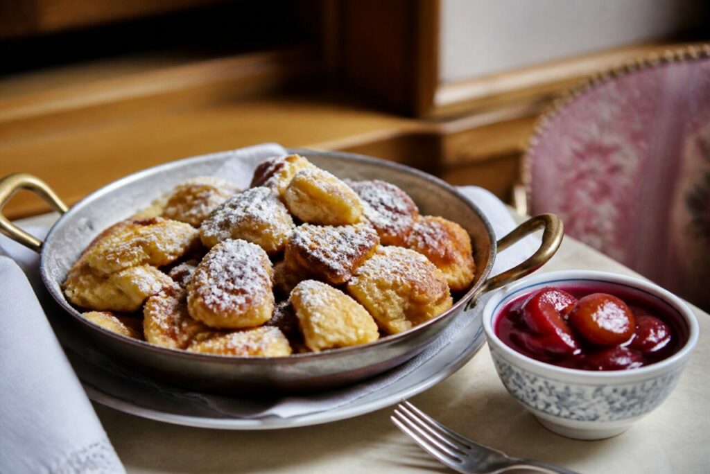 Kaiserschmarrn servi dans sa poêle en cuivre avec les prunes