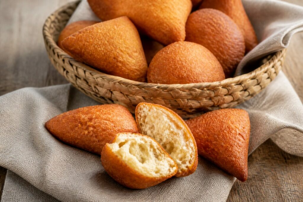 Mandazi africanos dorados con miga abierta en una composición