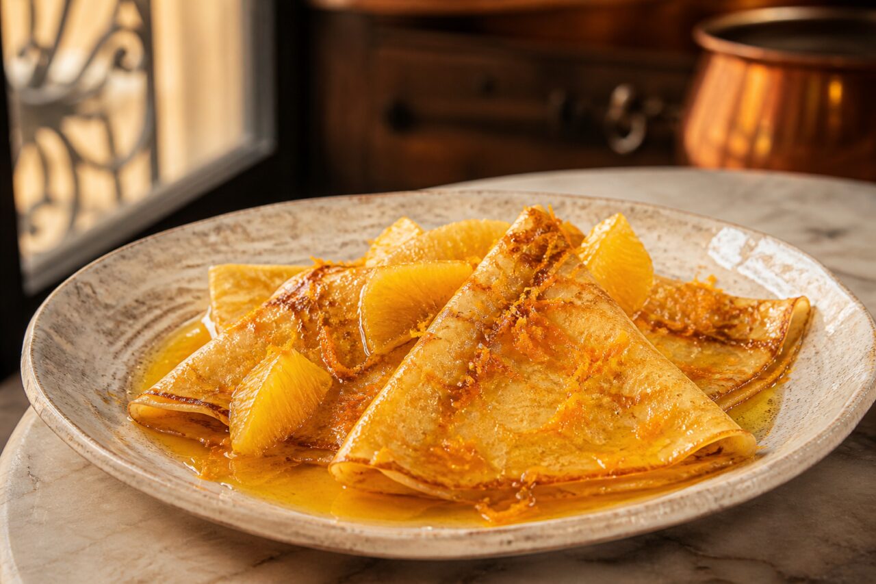 Salsa ambarina rodea las crepes Suzette plegadas