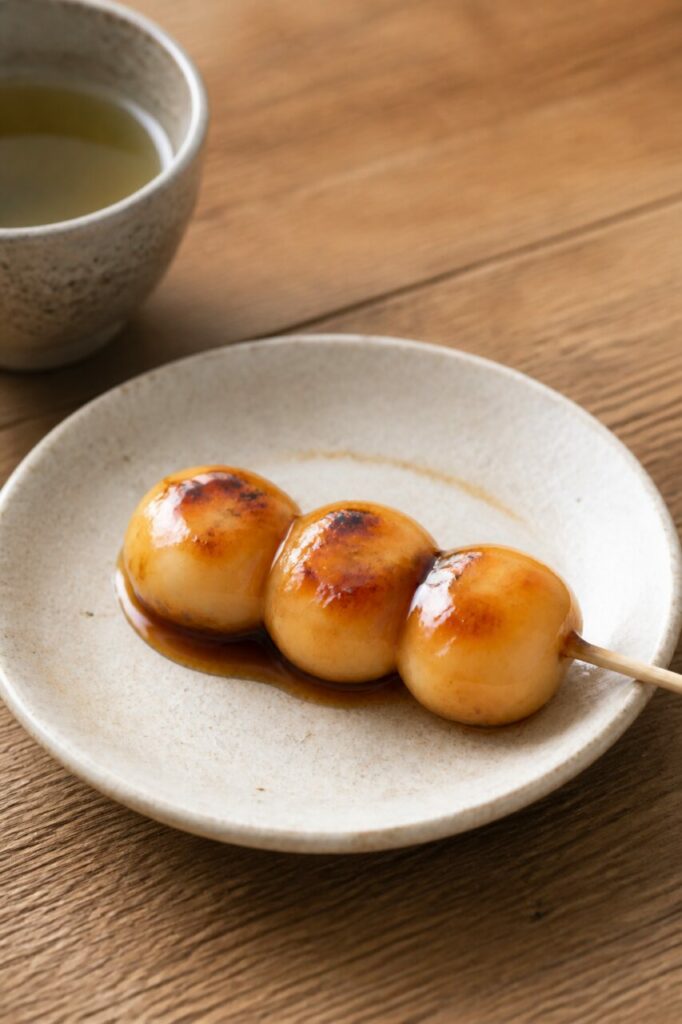 Salsa ámbar cubre los mitarashi dango ligeramente tostados