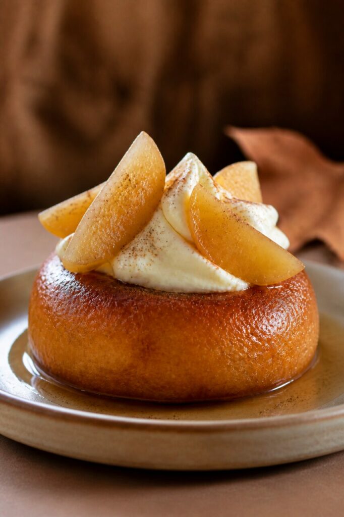 Amber syrup surrounds the poached pear savarin with cream
