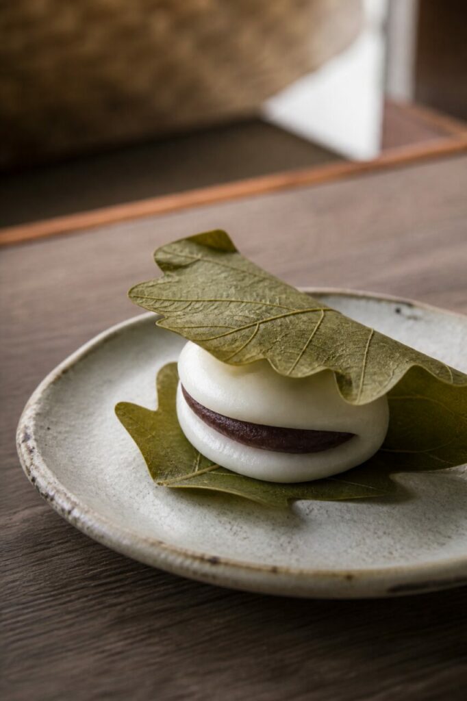 Un kashiwa mochi à l'anko posé sur la céramique rustique